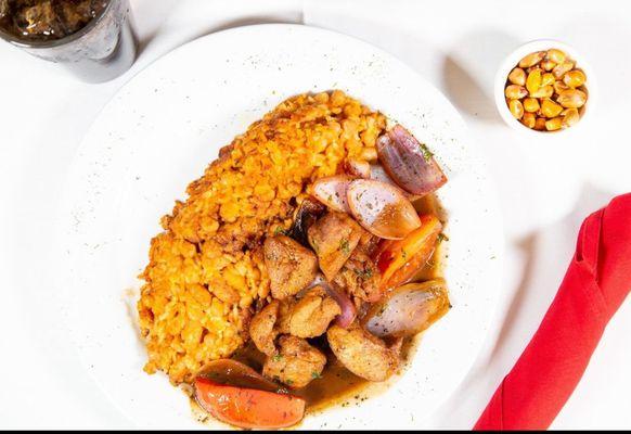 Tacu - Tacu with saltado de pollo. Beans mixed with rice on the site chicken sautéed with onions, tomatoes, soy sauce and, cilantro.