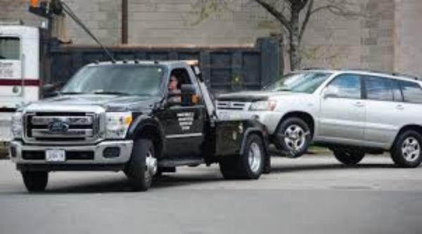 Tow truck towing car back to shop after repo