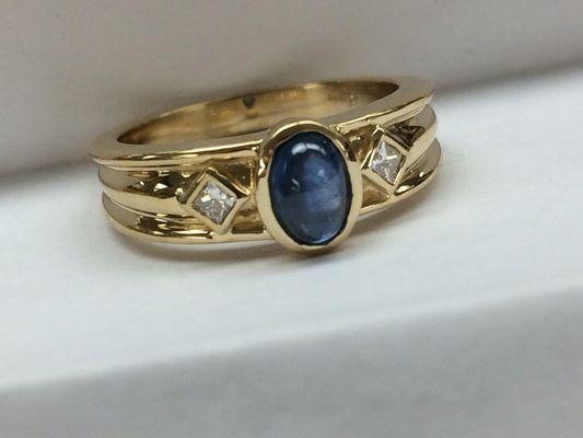 Art for everyday wear: sapphire cabochon with princess cut diamonds in 14 karat yellow gold band