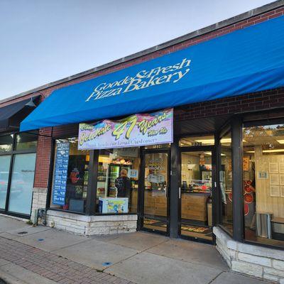 Outside the shop with celebration banner!