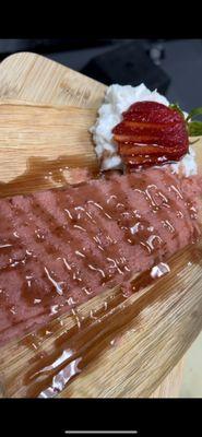 Strawberry tamale topped with strawberry jam, whipped cream and strawberry