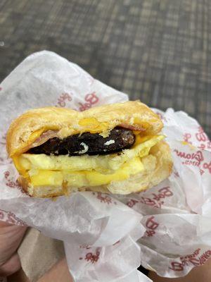 Bacon, egg, sausage, and cheese croissant breakfast sandwich