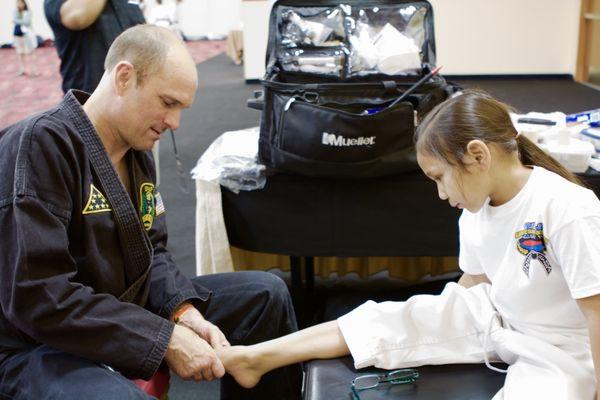 Dr. Wood treating an injured martial artist at the Chuck Norris International Training Conference in Las Vegas