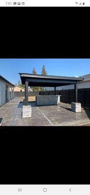 Back yard Stamp concrete patio and patio cover with stone columns