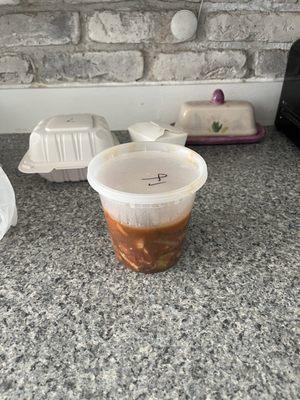 Small container of sweet n sour chicken half full