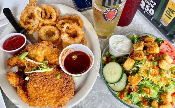 Deep fried chicken breast dinner with onion rings and side salad