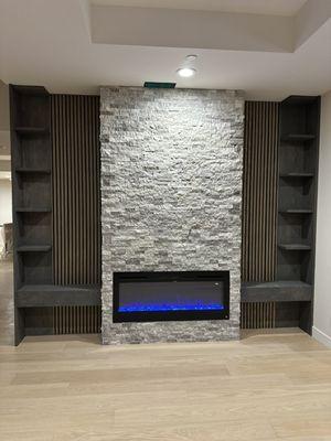 Tv entertainment area. Decorative stone wall and fireplace