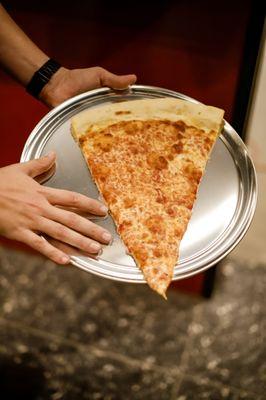 Seriously huge cheese pizza slice- bigger than your hand!