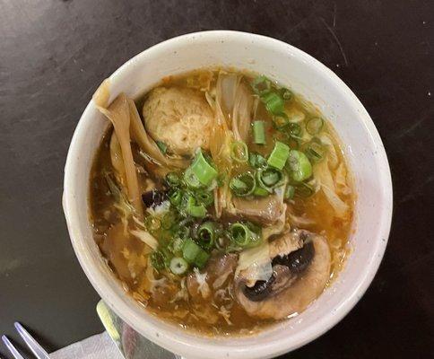 Hot and sour soup topped with chopped green onions