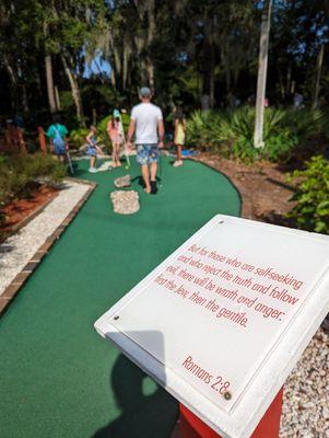 Sign on mini golf course warning of god's wrath.