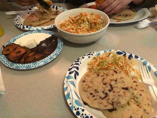 2 papusas, vegetable toppings (ensalada picante), and fried plantains (with crema, beans, and cheese)