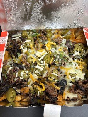 Loaded Texas fries French fries, smoked brisket, housemade cheese sauce, BBQ sauce, pickled peppers sweet and spicy and so amazing