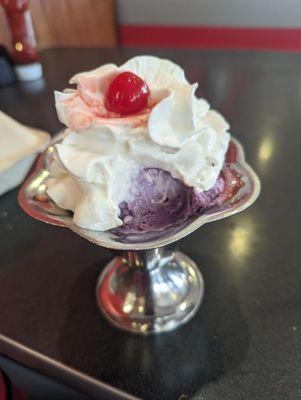 Black raspberry ice cream with strawberries and whipped cream.