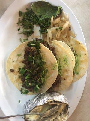 4 Steak Tacos with a baked potato, cilantro and onions. Also received a cup of fideo soup (yummmm) with my plate.