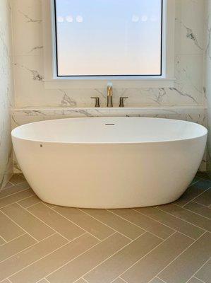 Herringbone tile adds extra elegance to this luxurious soaking tub.