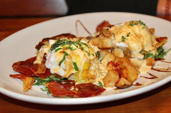 The Italian Benedict was made with two eggs, prosciutto, greens, basil, sun-dried tomato hollandaise, balsamic, polenta cakes, & potatoes.