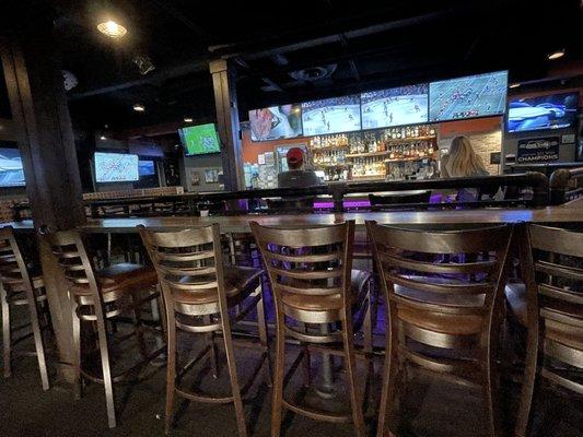 Several rows of bar seating for a good view of TVs.