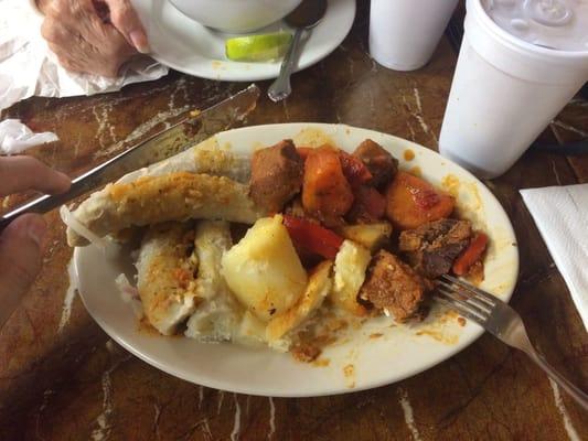 Big chunks of beef in a stew over green bananas and cassava.