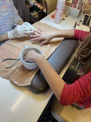 A daughter getting a manicure.