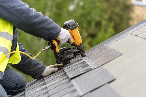 Roofer Installing Asphalt Shingles on Roof