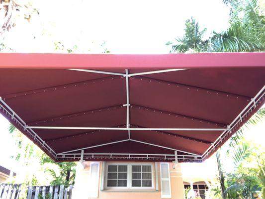 Custom carport with a white structure and sunbrella terra-cotta canvas