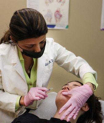 Dr. Nambiar administering lip fillers on a patient