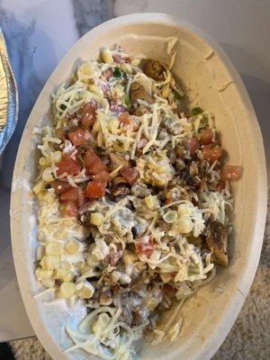 Chicken burrito bowl with cheese, corn, salsa, and missing black beans