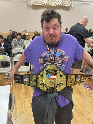 Holding a real WCW United States Heavyweight Championship belt that is owned by one of the Big Time Wrestling staff members