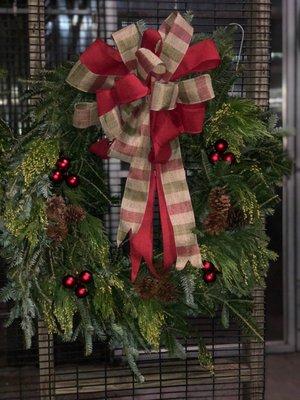 Mixed greens on a wreath with double bow