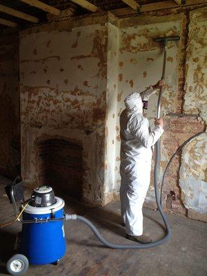 HEPA vacuuming vertical surfaces to remove settled mold spores.