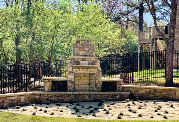 Stacked stone fire place, wall, bench with irregular flagstone patio with slate mix and dwarf mondo grass