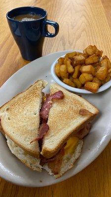 Fried Bacon & Egg sandwich and Home Fries with coffee.