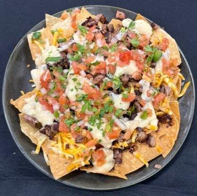 Brisket Nachos smothered in cheese and Queso topped with Pico de gallo