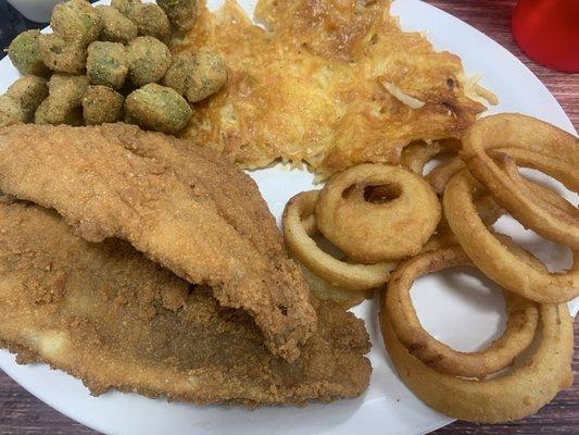 Fried catfish dinner with hash brown casserole, fried okra and onion rings.