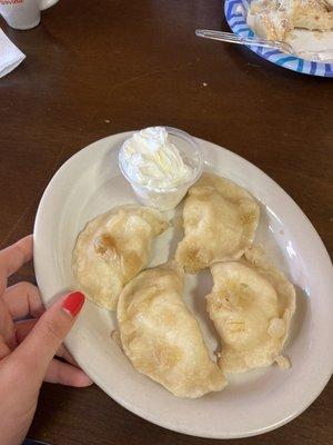 Mashed potato and cheese pierogis with sour cream