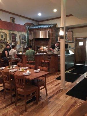 View from bar to a seating area near brick oven.