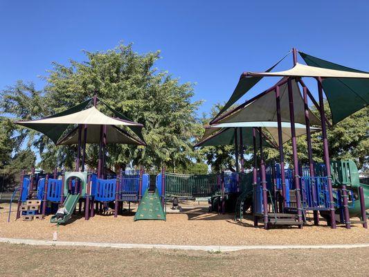 Large playground with shade coverings and barns floor.