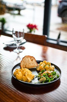 Scrambled eggs with potatoes, home-made bread and salad.