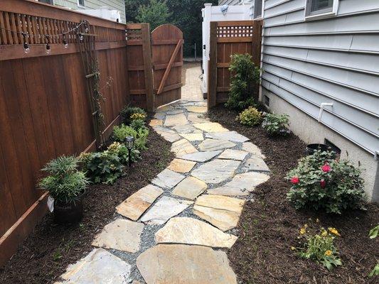 An awesome flagstone walkway with landscaped mulch and new plants