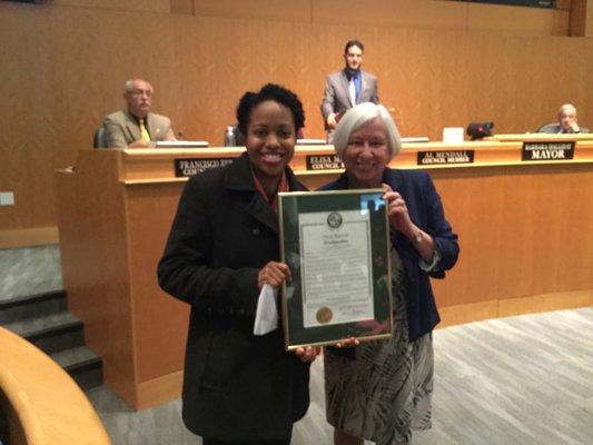 Cherisse Baptiste accepting the April Fair Housing Month Proclamation from Mayor Halliday.