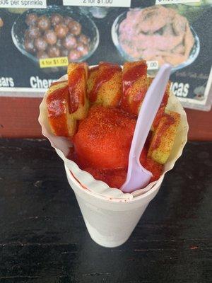 Watermelon raspa with cucumber slices, tajin and chamoy.