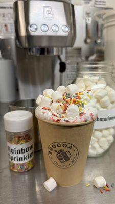 Unicorn Dreamsicle: white chocolate hot cocoa, raspberry and toasted marshmallow with whipped cream, marshmallows, and sprinkles