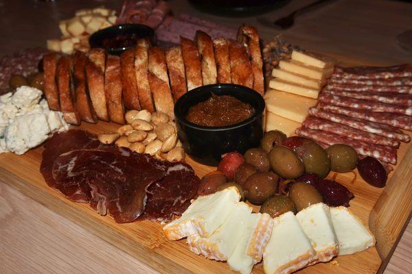 The Charcuterie made with the Chef's selection of cheeses, locally sourced cured meats, grilled baguette, & seasonal accoutrements.