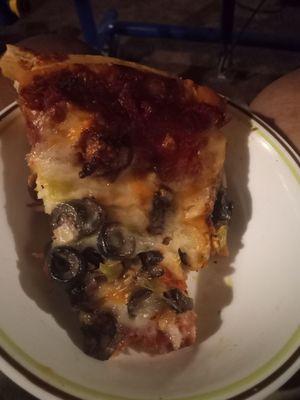 This is the slice of a piece of pizza that was supposed to be a supreme  Too many black olives and extra cheese that wasn't ordered