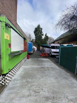 Looking down the pod, dumpsters and porta potties to the right, food carts on both sides