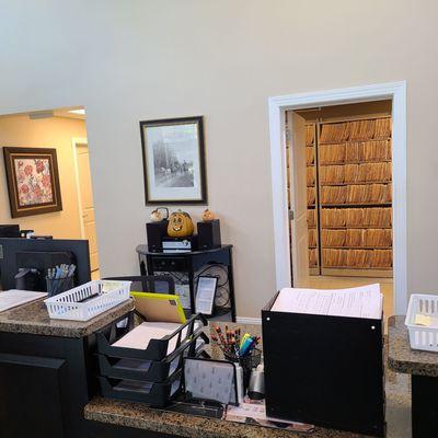 The reception area with the paper files in the background room.