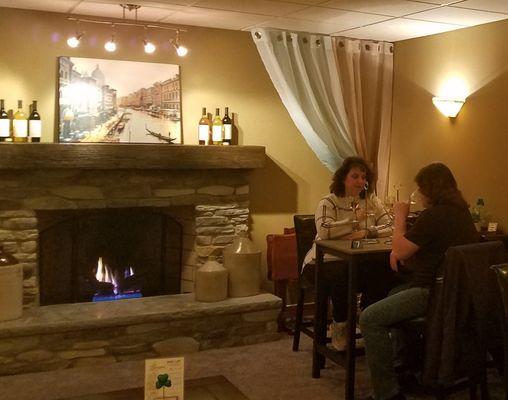 Customers enjoying some wine near the fireplace