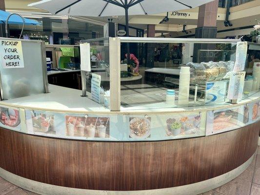 Circular counter in center of the mall 1st level near escalators & food court