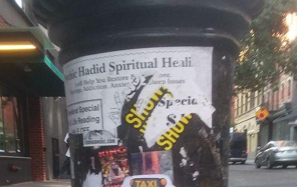 The tattered remnants of a sticker on a lamp post on Ludlow St. advertising the biz.