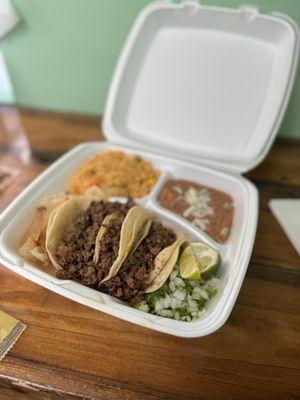 Three fajita steak tacos and rice and beans.